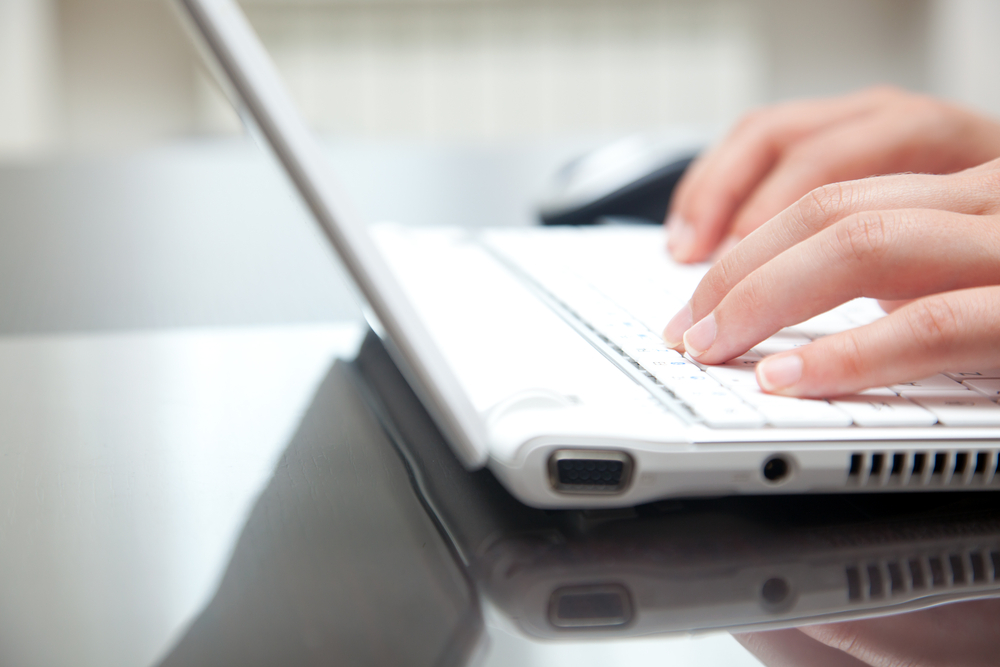 hands typing on a laptop